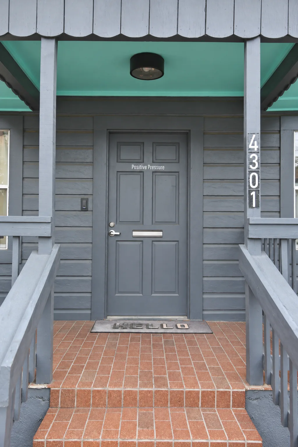 Positive Pressure porch entrance, with the business name on the door and street number 4301 on the right post.