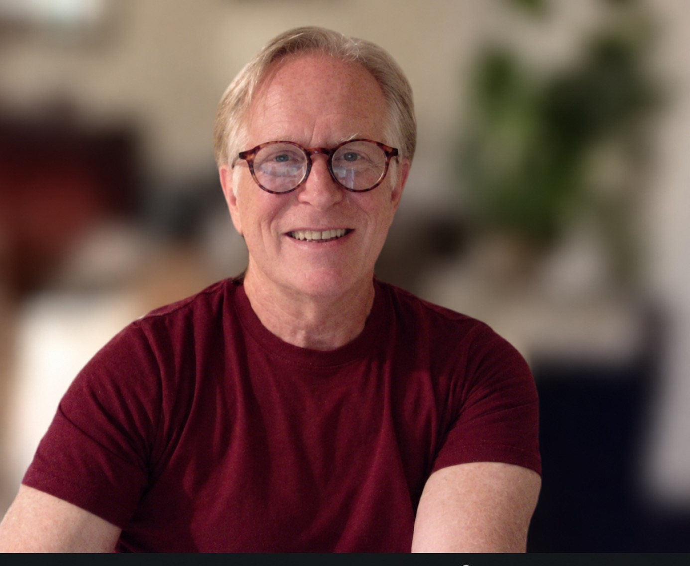 Erik Kuykendall smiling, wearing glasses and a burgundy shirt.